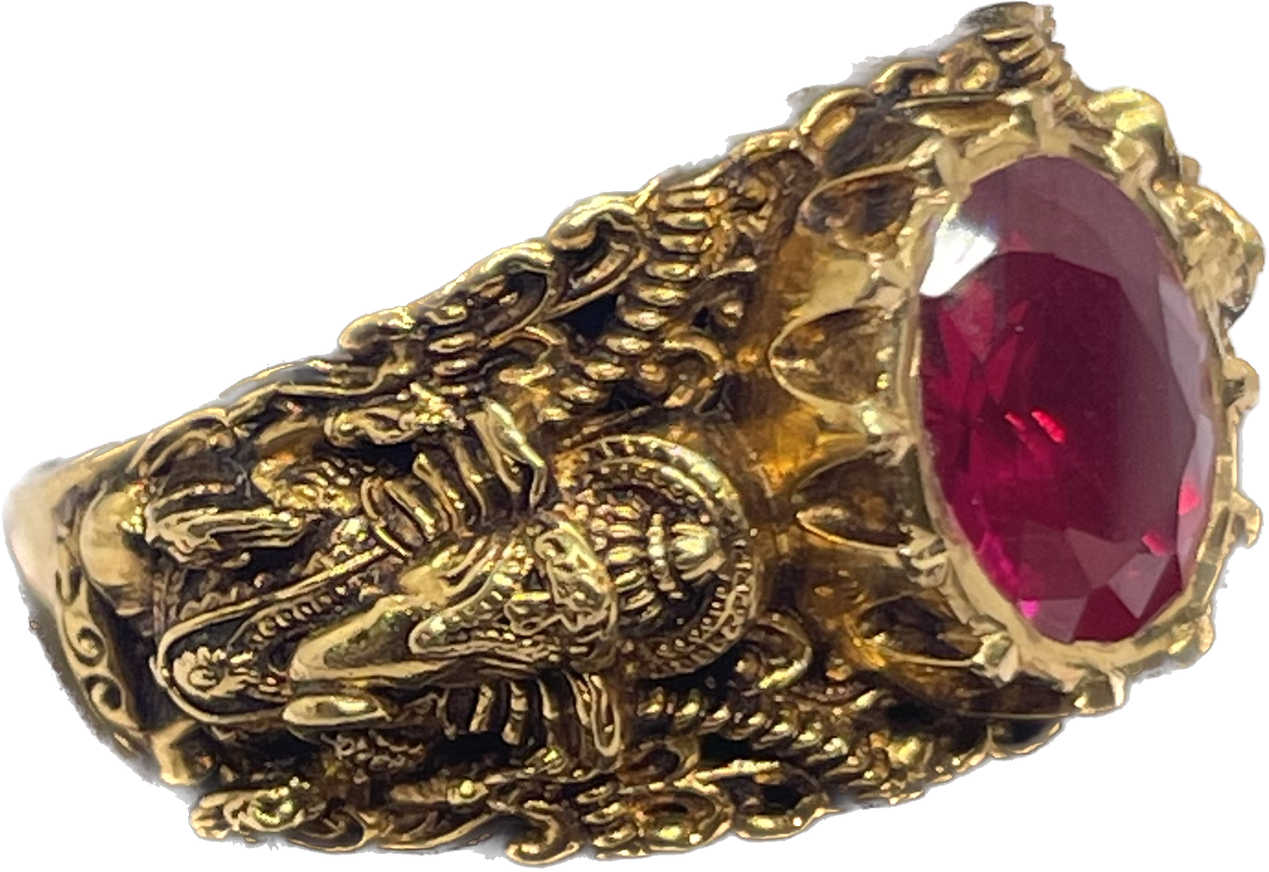 An ornate ring with an oval red stone and sculpted detailing.